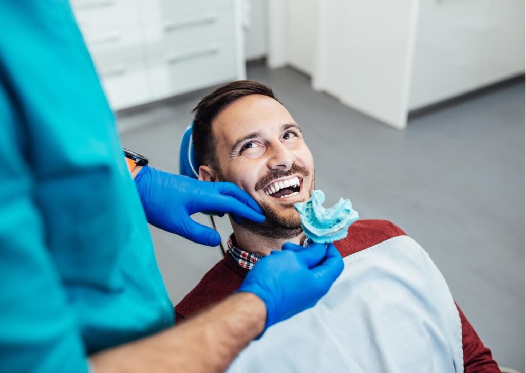Patient reviewing dental impressions and treatment options for dental bonding or veneers with a cosmetic dentist