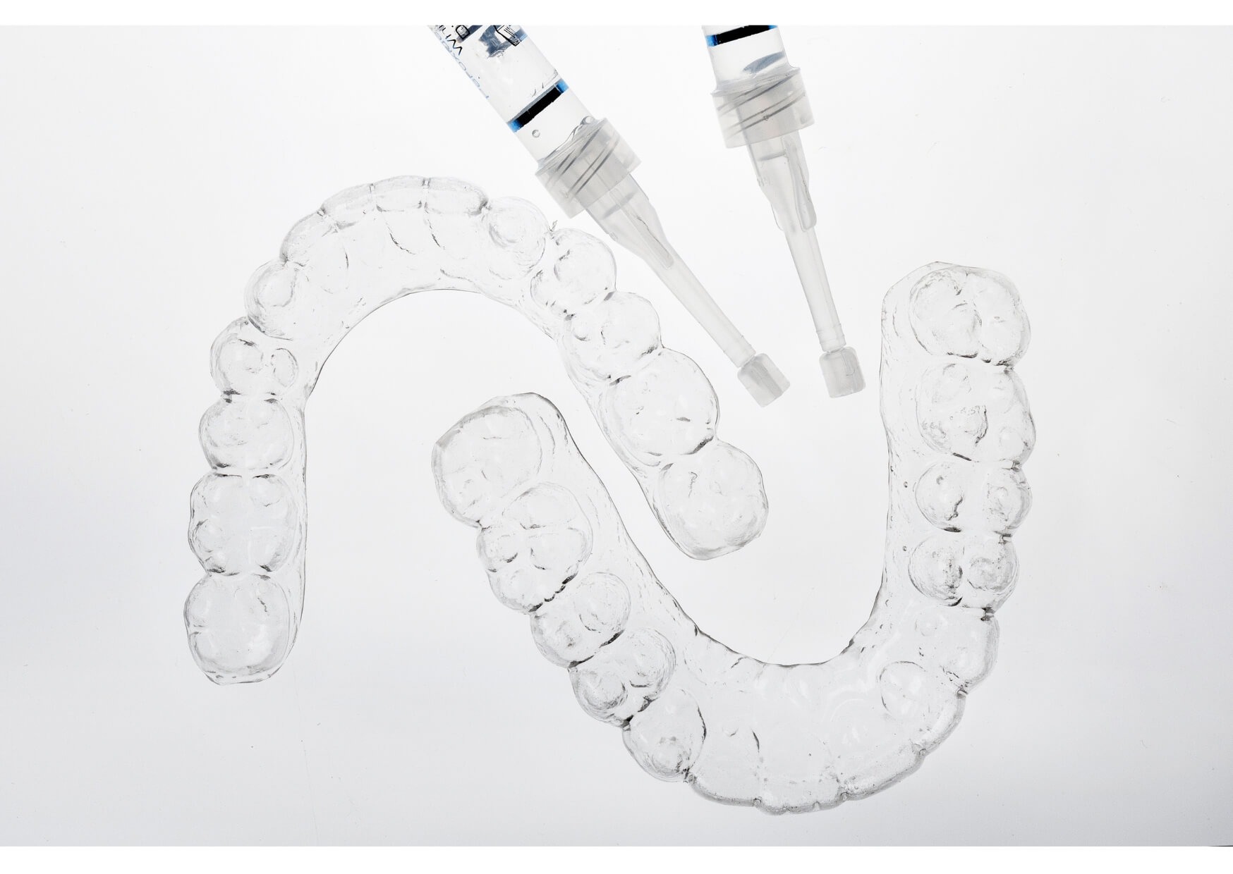 Custom clear nightguards for teeth grinding displayed with dental impression trays and dental materials for bruxism protection