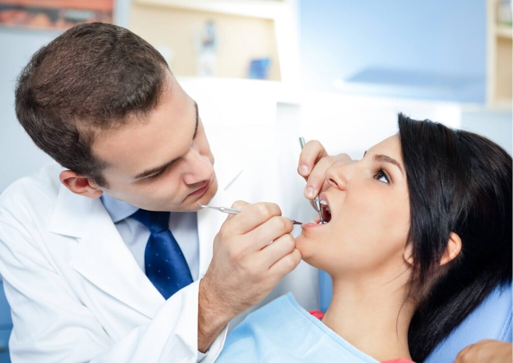 Dentist examining a patient's back molars to evaluate a wisdom tooth coming in and check for signs of crowding or irritation.