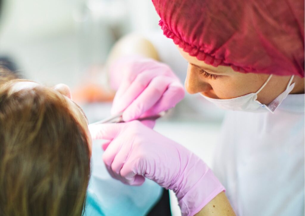 Dentist examining a patient's loose adult tooth to determine the cause and recommend appropriate treatment.