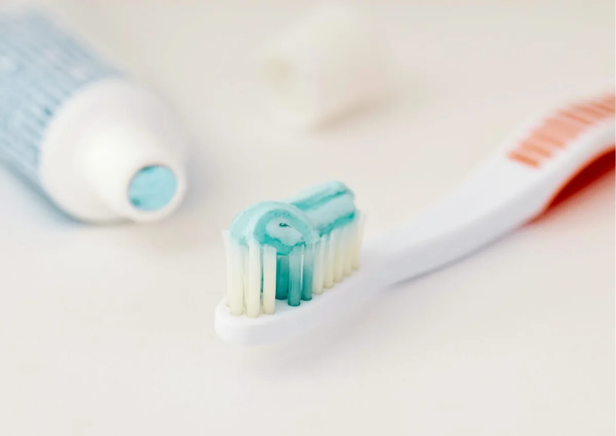 Toothbrush and fluoride toothpaste representing daily care for different types of dental crowns.