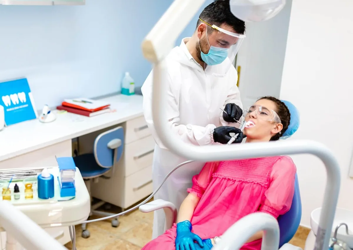 Dentist examining a patient’s extraction site to check for normal healing after tooth extraction.