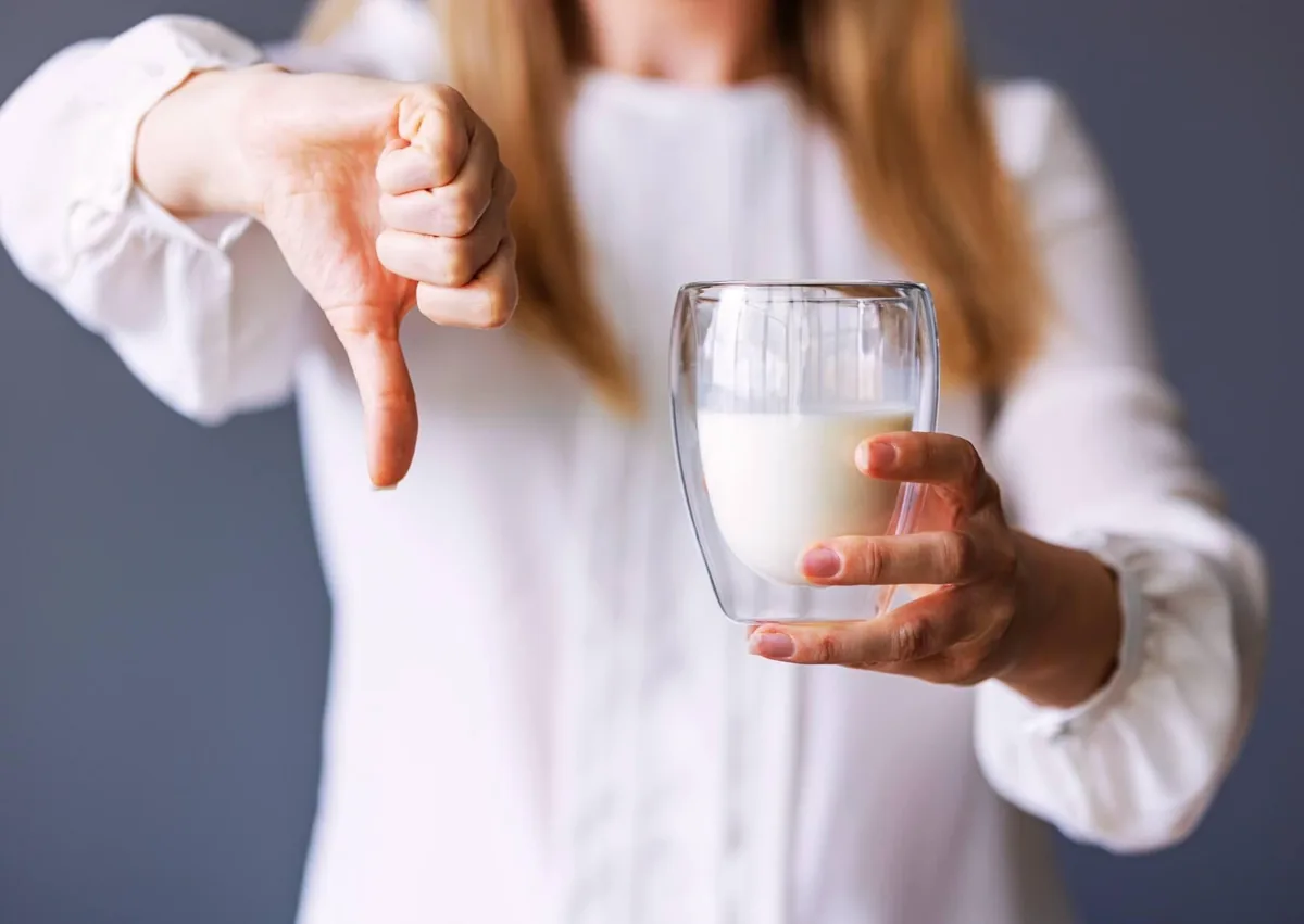 Woman avoiding milk and dairy products during recovery after dental implant surgery.