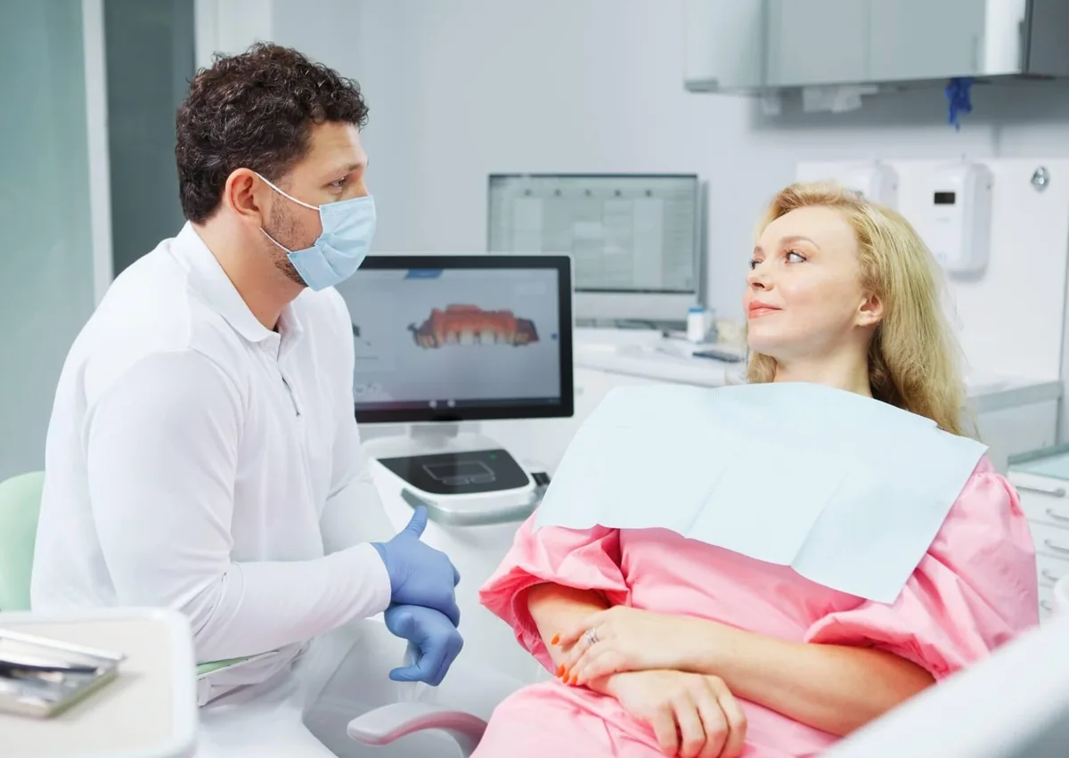 Patient discussing post-surgery care with a dentist after dental implant treatment.